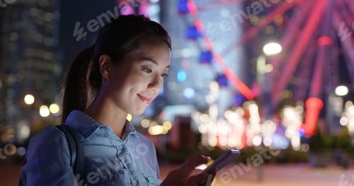 Preview: Woman look at mobile phone in city at night