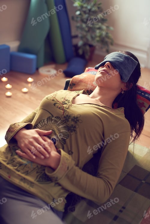 Preview: Attractive mixed race woman doing restorative yoga