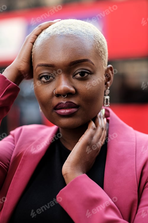 Preview: Young businesswoman posing with hand on head and neck in urban setting