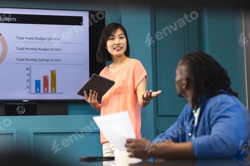 Preview: Asian woman presenting, African American man listening in a modern business office