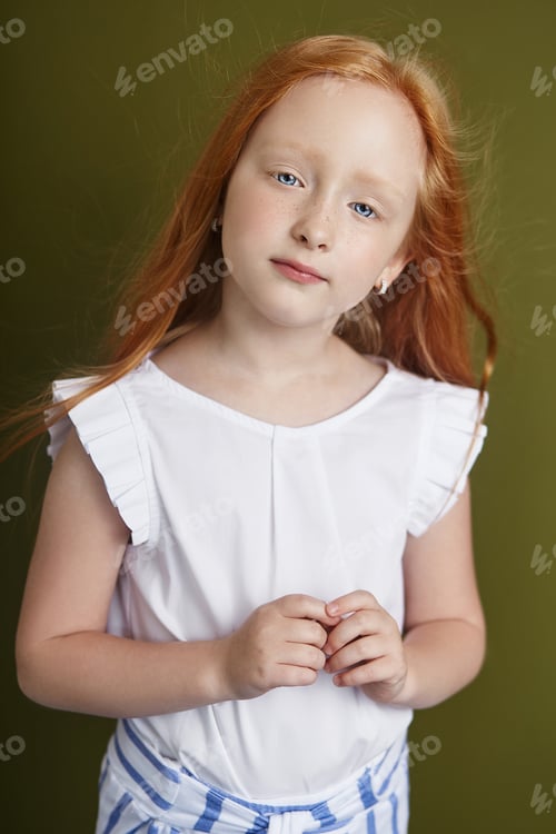 Preview: Beautiful red-haired girl with long hair and beautiful big blue eyes. Redhead Girl child in summer