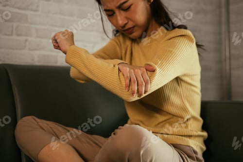 Preview: Young female suffering from elbow pain