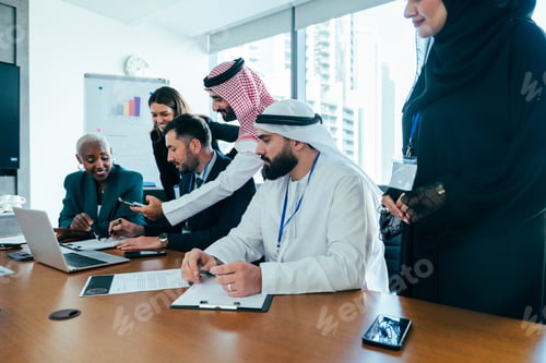 Preview: Multiethnic business team collaborating on project during office meeting in dubai