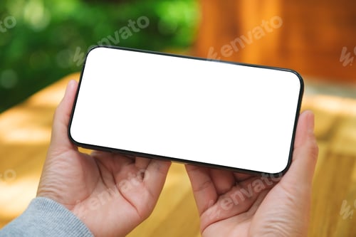 Preview: Mockup image of a woman holding mobile phone with blank white desktop screen in the outdoors