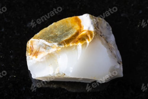Preview: sample of raw white opal mineral on black granite