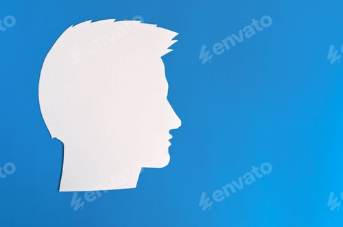 Preview: The silhouette of the guy's head. a concept with copy space. cut out of paper on a blue background.