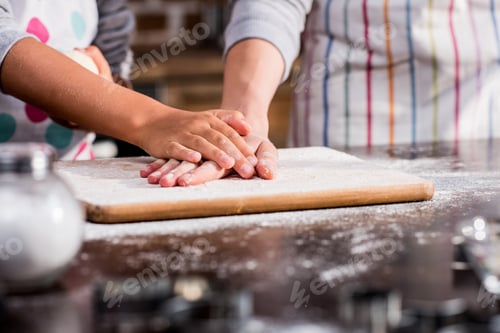 Preview: partial view of family holding hands on raw dough while cooking together