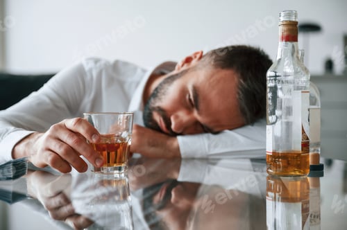 Preview: Conception of addiction. Upset young man drinker alcoholic is indoors