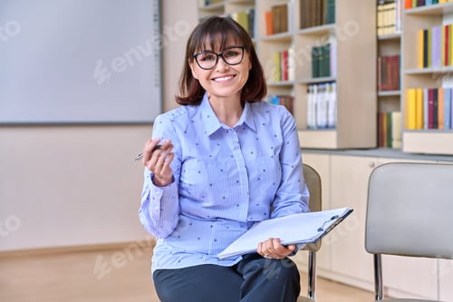 Preview: Woman teacher, counselor looking at camera in library class