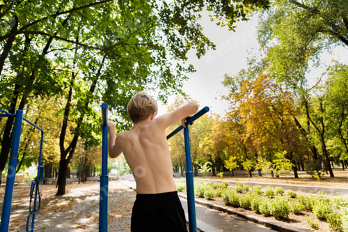 Preview: Athletic boy trying to climb on an exercise shell.