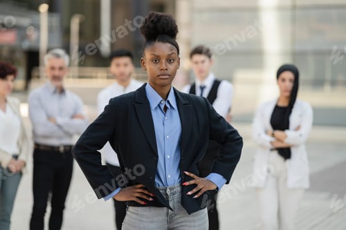 Preview: portrait of female african american businesswoman, and her team of workers outside