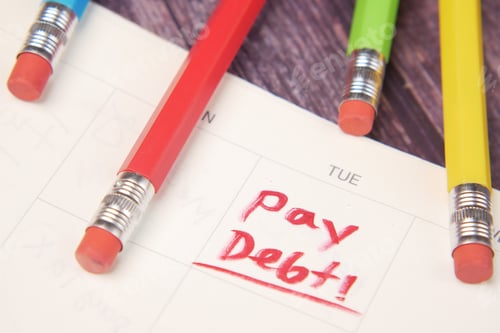 Preview: Close up of pay debt word on calendar