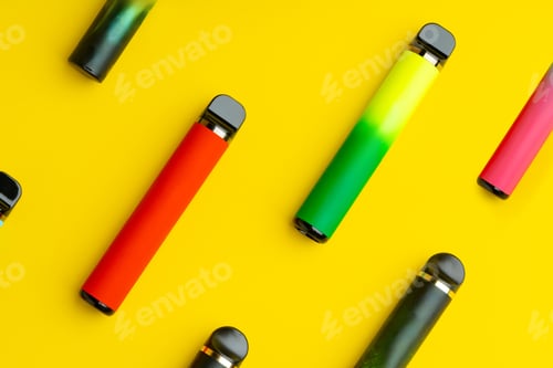 Preview: Colorful disposable electronic cigarettes on yellow background