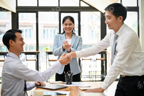 Preview: A businessman shaking hands with his colleague, welcoming a new coworker.