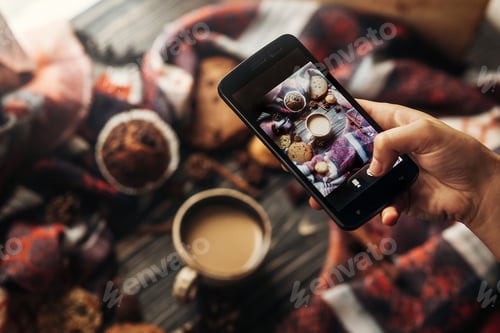 Preview: Hand holding phone taking photo of coffee cookies and spices