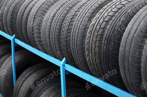 Preview: Rack with variety of car tires in automobile store. Many black tires. Tire stack background