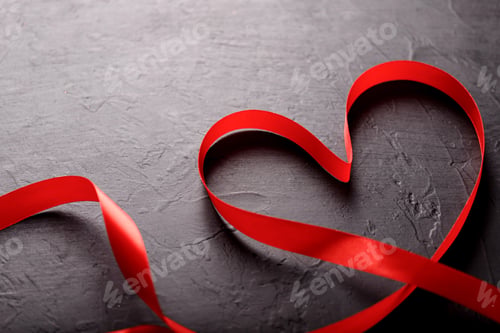 Preview: Happy Valentines Day. Red Ribbon on black stone background. Valentines Day concept