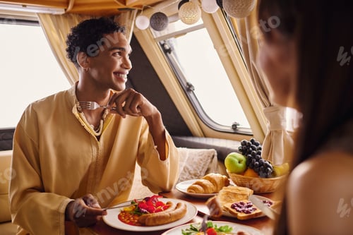 Preview: Happy Young Couple Enjoying Meal in Camper Van