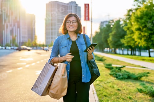 Preview: Urban portrait of middle aged woman with shopping bags in mall parking