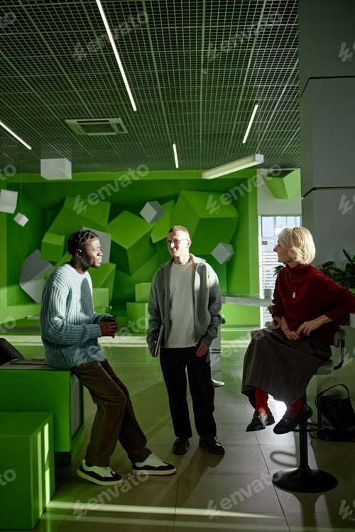 Preview: Multiethnic Young Adults Socializing and Smiling in Modern Office Lounge