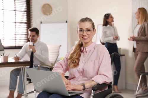 Preview: Portrait of woman in wheelchair with laptop and her colleagues at workplace