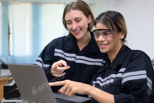 Preview: Happy female engineers team using laptop checking and operating