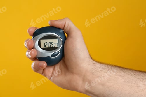 Preview: Man holding digital timer on yellow background, closeup