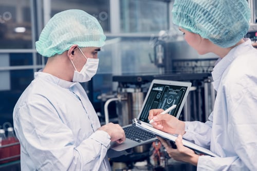 Preview: Food and Drink factory worker working together with hygiene monitor control mix ingredients machine