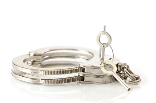 Preview: Close-up of metal handcuffs and key in keyhole