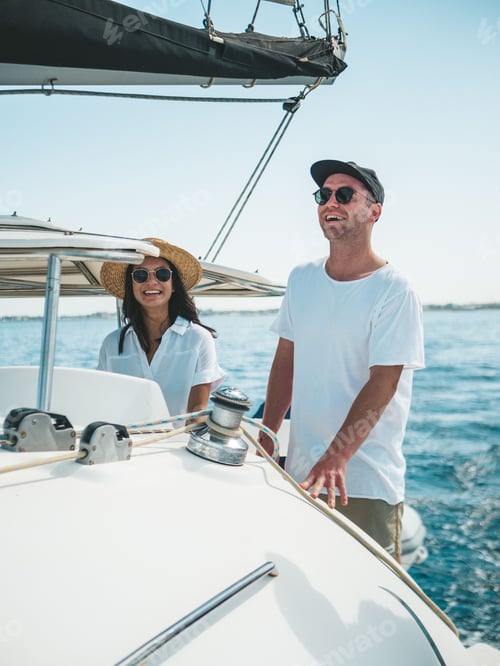 Preview: Happy caucasian couple standing on the yacht in clear ocean water