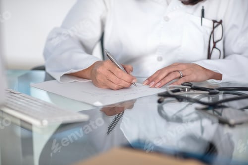 Preview: Cropped view of doctor writing prescription