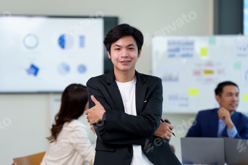 Preview: Confident asian businessman stand in a corporate office setting.