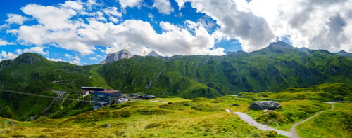 Preview: Picturesque Mountain Village of Kaprun, Austria with Lush Green Hills and Traditional Houses