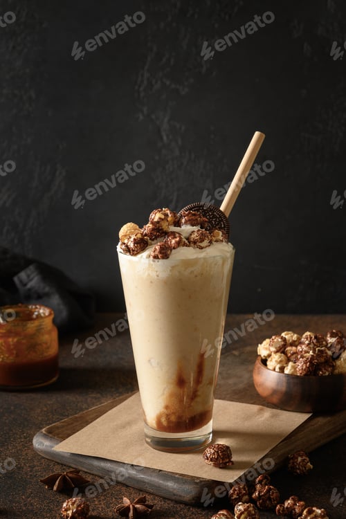 Preview: Tasty banana milkshake garnished caramel, whipped cream, popcorn. Vertical format