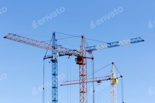 Construction Cranes Against Blue Sky Urban Development