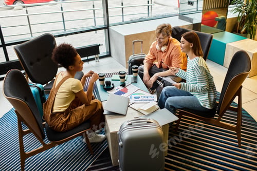 Preview: Colleagues discuss hotel trip plans during an indoor business gathering