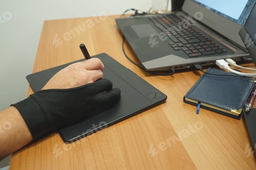 Preview: Man designer freelancer use a graphics tablet with touch screen and pen in the office