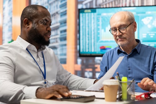Preview: Financial banker using a calculator to create a projection for senior clients