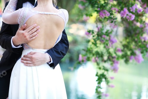 Preview: Beautiful bride and groom standing by the lake at sunset