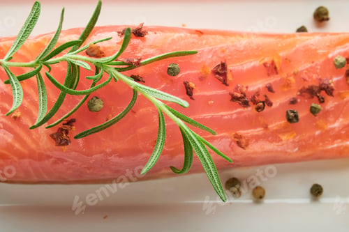 Vista previa: Pieza de pescado con salmón. Pieza de pescado fresco de salmón crudo sobre tabla de mármol con hierbas y limón sobre fondo negro