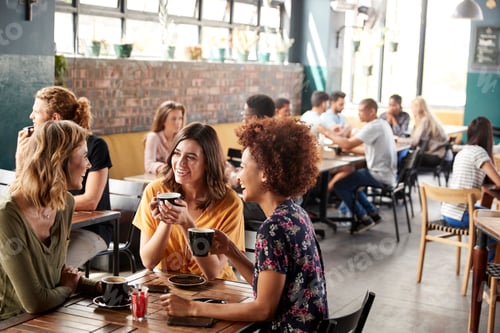 Preview: Three Young Female Friends Meeting Sit At Table In Coffee Shop And Talk