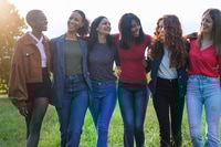 Preview: Group of empowered women walking together in the park at sunset