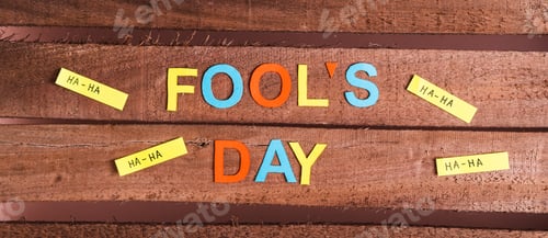 Preview: April Fools Day from colored letters, funny notes and paper on wooden top view web banner