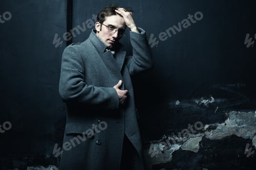 Preview: Artistic dark portrait of the young beautiful man in a gray coat