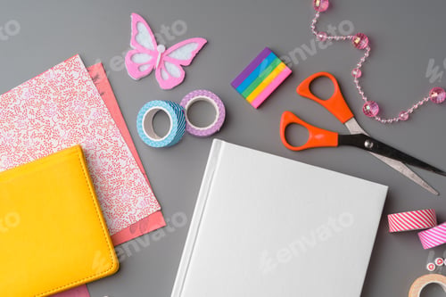 Preview: Crafting supplies arranged for a DIY project on a gray table with scissors, washi tape, and