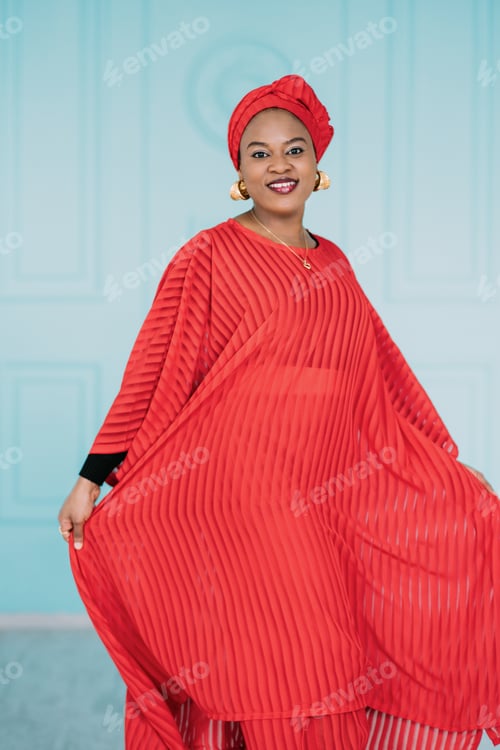 Preview: A portrait of pretty African lady wearing red stylish clothes and headwrap, posing with happy smile