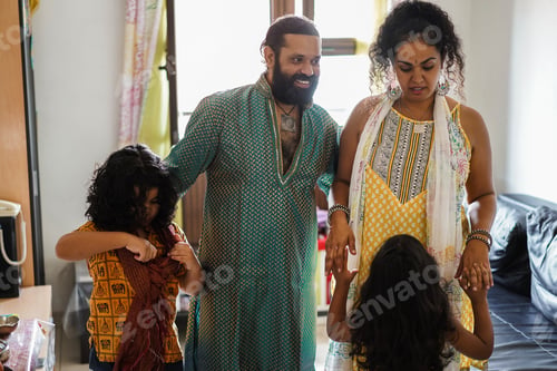 Preview: Happy indian family having fun at home - Focus on man face