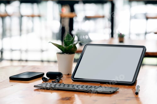 Preview: Mockup portable tablet with keyboard and gadget on wooden table in office room.