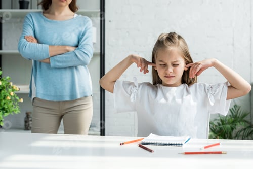 Preview: cropped view of woman standing with crossed arms near kid covering ears at home