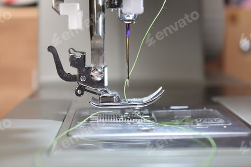 Preview: Closeup picture of sewing machine foot and needle with thread